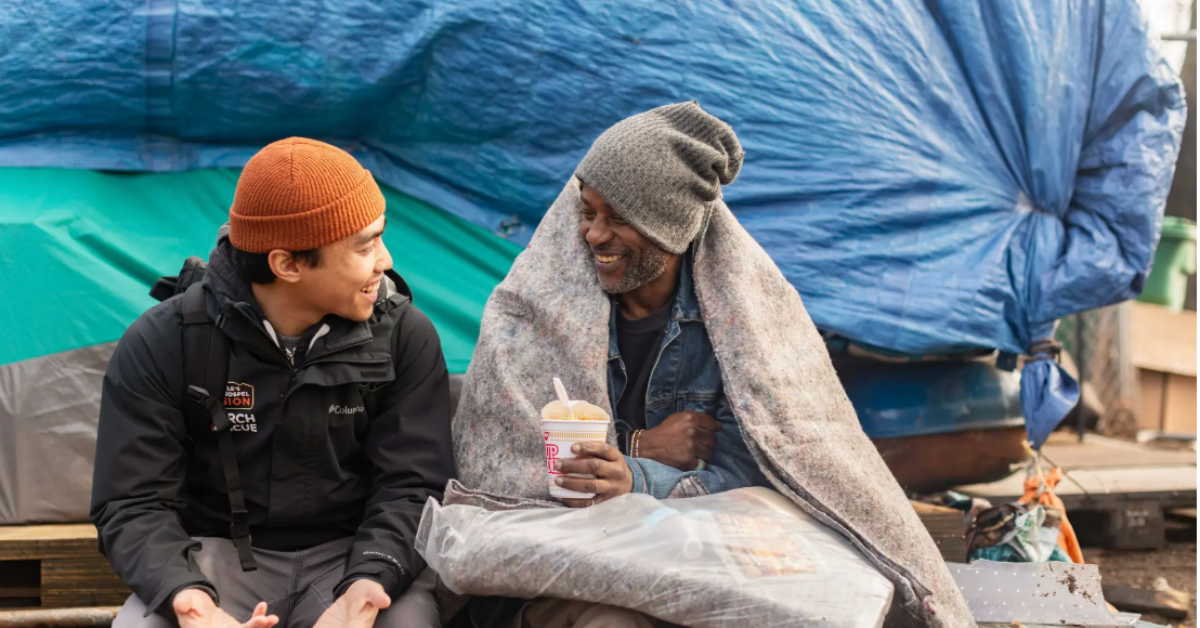 A Seattle’s Union Gospel Mission employee sits with a homeless man, listening and offering support.